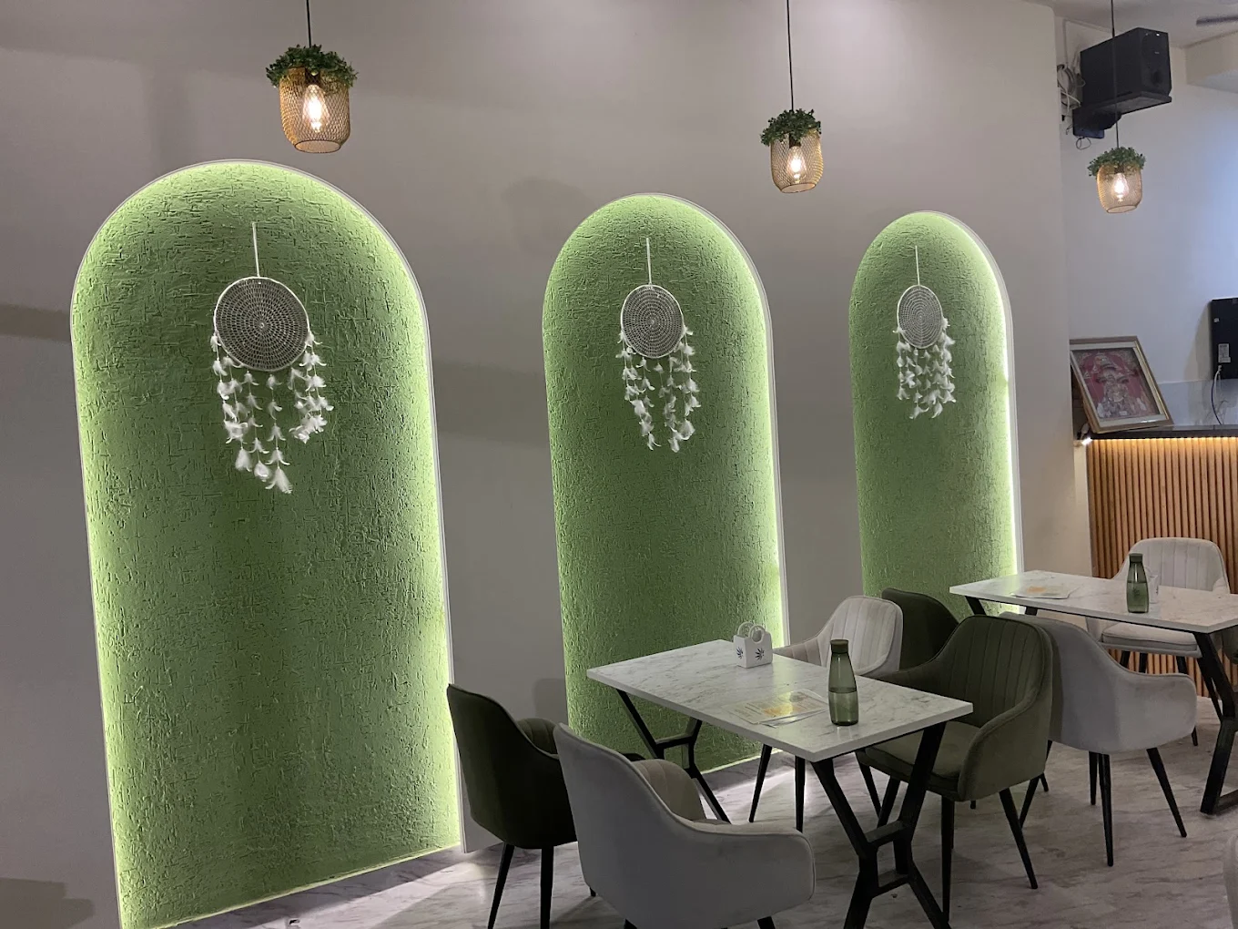 KAAFII Café Newai — iconic green arches with dream catchers
